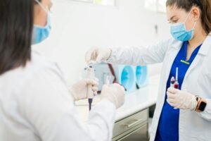 Healthcare professionals performing blood tests in a laboratory setting.
